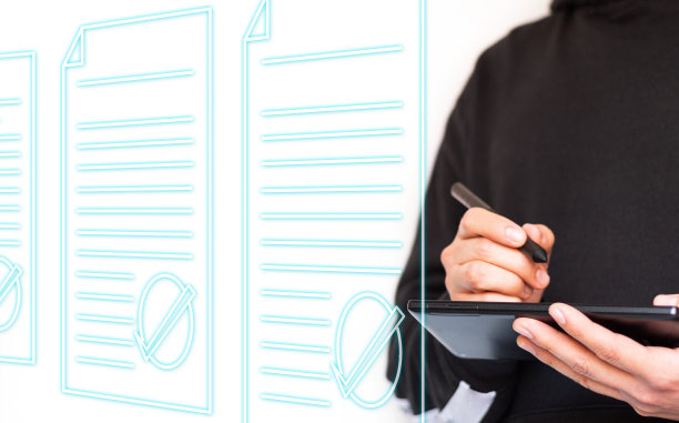 一个穿着连帽衫，面目不清的年轻人拿着平板电脑和数字笔查看文件。全息文件。千禧年的商人。图片下载