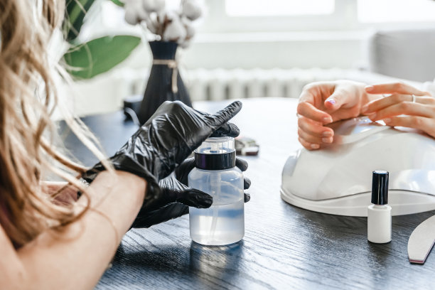 美容院的专业美甲师。修甲服务，手部护理，指甲，手指护理。多色指甲油，样品调色板，纹身，角质层油，凝胶紫外线灯，手套图片下载