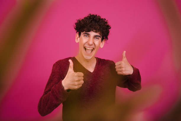 运动和健康的生活方式。有趣的情绪化的家伙在粉红色的背景上摆姿势。图片下载