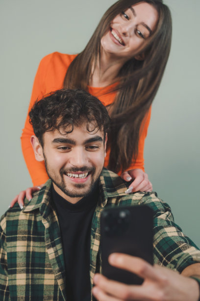 男人和女人用手机拍照和拍摄的正面肖像，孤立在灰色背景上，年轻博主的概念。分享视频到社交媒体应用程序图片下载