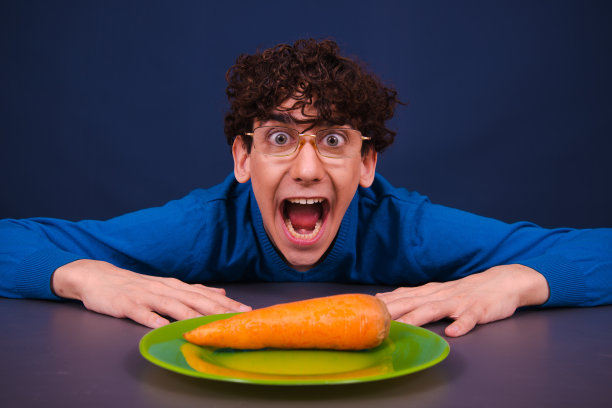 滑稽的傻瓜吃胡萝卜。饮食和健康的生活方式。图片下载