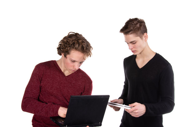 两个年轻漂亮的学生拿着笔记本电脑。图片下载