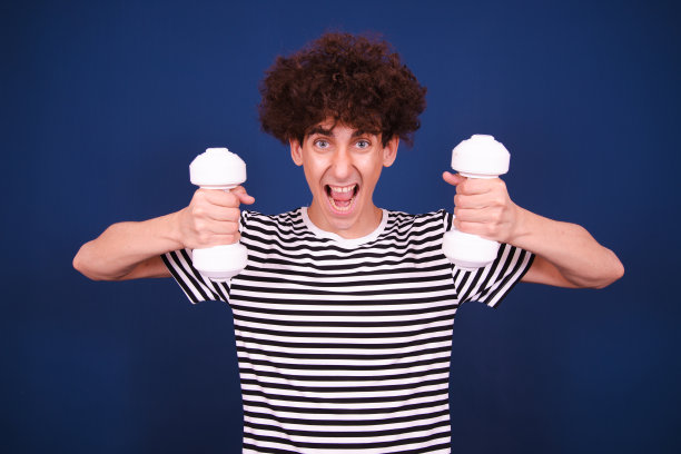 滑稽的家伙在用哑铃健身。图片下载