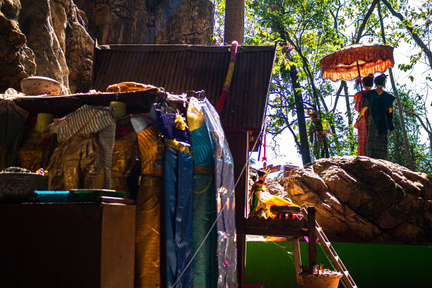 两尊带遮阳伞的雕像就在华通洞外(靠近华通瀑布)。 泰国佛教神话和民间传说中的神圣雕像:泰国寺庙之旅图片下载