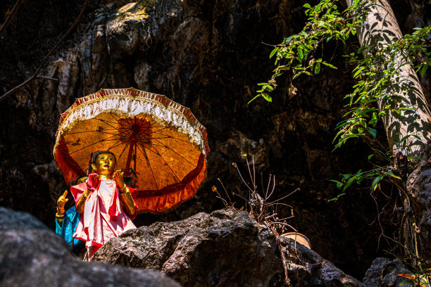 两尊带遮阳伞的雕像就在华通洞外(靠近华通瀑布)。 泰国佛教神话和民间传说中的神圣雕像:泰国寺庙之旅图片下载