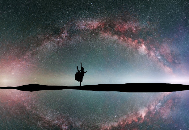 女人的剪影在夜晚跳舞健身，在明亮的银河背景下。图片下载