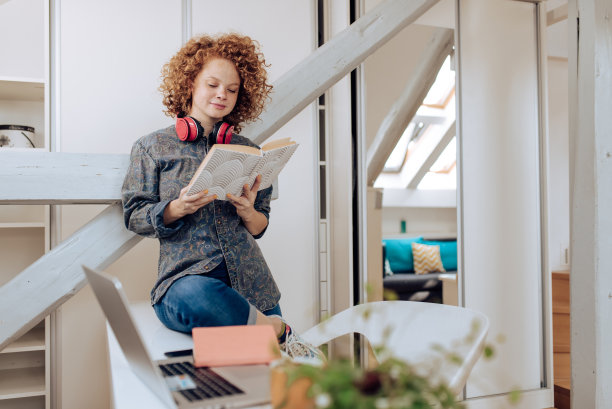 美丽的女孩在她的家庭办公室读书图片下载