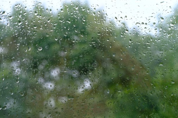 窗外的秋雨，橘黄色的树叶失去焦点，玻璃背景的纹理有水滴，文字的位置，水平横幅有模糊的散景，自然保护，恶劣的天气图片下载