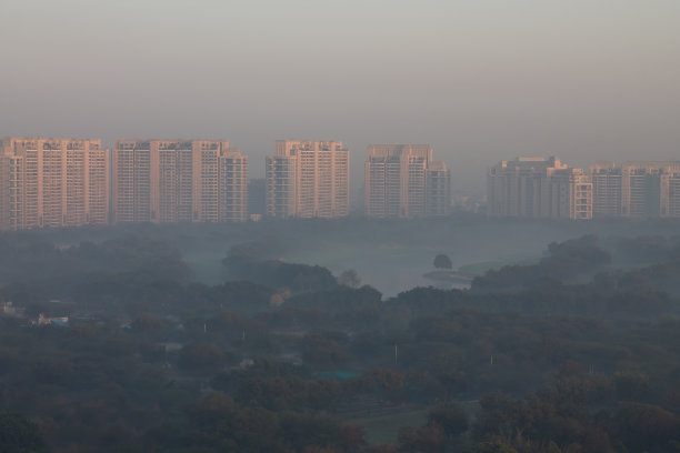 古鲁格拉姆市豪华住宅公寓鸟瞰冬季日出，湖泊被雾包围。图片下载