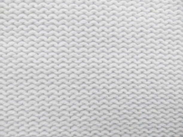毛线针织衣服。纱架用毛纱的底色。手工艺品背景用白色针织纱。毛纱背景图片下载