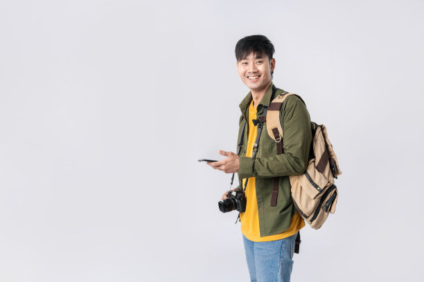 肖像年轻的亚洲男子背包客快乐的微笑在正式的衬衫使用智能手机交易或聊天或网上购物在孤立的工作室白色背景。摄影棚里的亚洲旅行者。图片下载