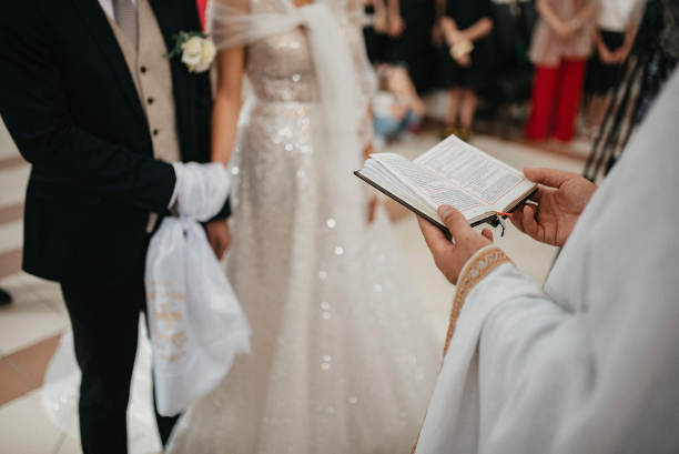 婚礼在教堂举行。神父把金戒指戴在新娘的手指上。婚礼蜡烛。图片下载