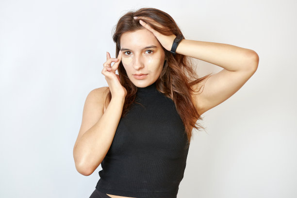 美丽的女孩在脸上涂粉底。图片下载