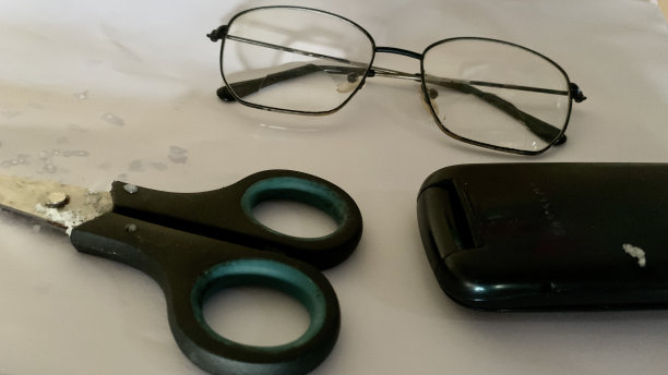 白纸上眼镜、剪刀和手机的特写镜头图片下载