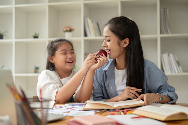 一个快乐的年轻亚洲女孩正在享受在家跟老师学习英语的乐趣。图片下载