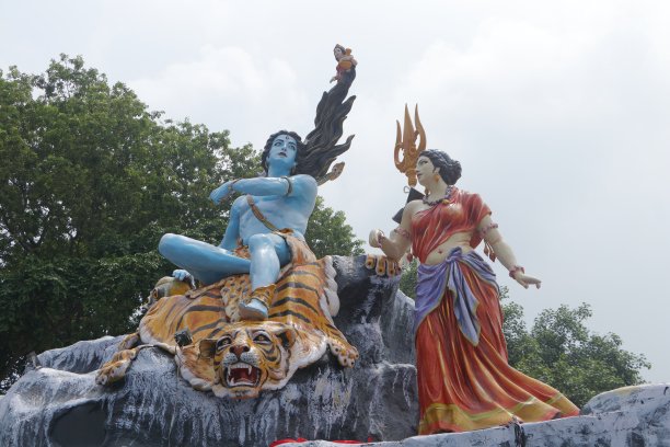 湿婆神和帕瓦蒂的巨大雕像，湿婆神坐在老虎背上，女神恒河坐在她的头发上，不同角度和焦点的照片。图片下载