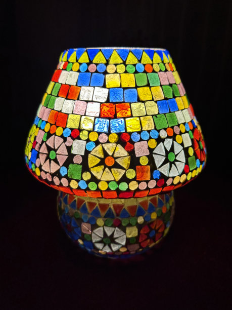 特写图像照明，彩色，马赛克彩色玻璃灯和灯罩在黑暗的背景下，重点在前景图片下载
