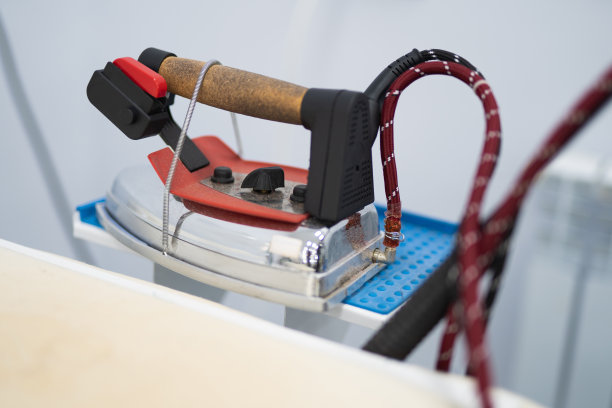 一名工人在缝纫厂熨衣服图片下载