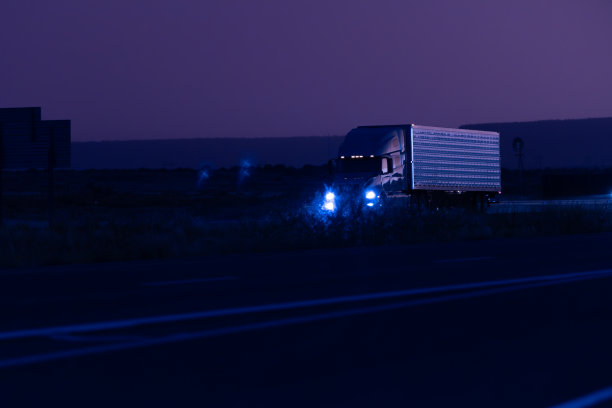 在令人惊叹的日落时分，货运卡车在州际高速公路上运送货物图片下载
