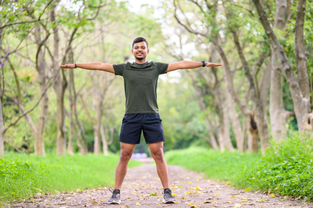 一个年轻的运动男子开始他的日常锻炼伸展运动的镜头图片下载