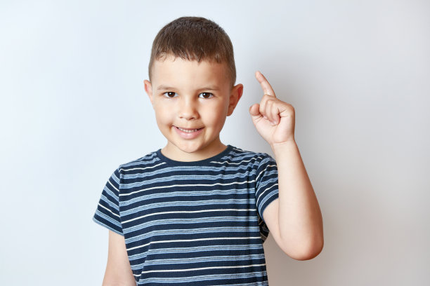 小男孩用食指举起他的手。注意和谨慎的概念。图片下载
