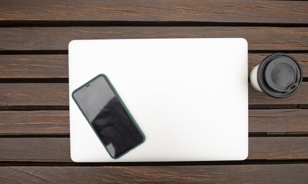 木制背景的笔记本电脑和咖啡，户外办公室。图片下载