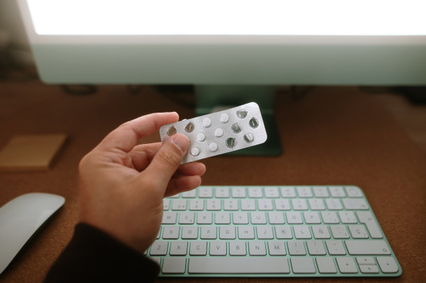 在办公桌旁拿着药片图片下载