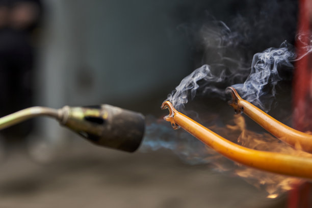 使用喷灯去除橙色自行车叉上的油漆图片下载