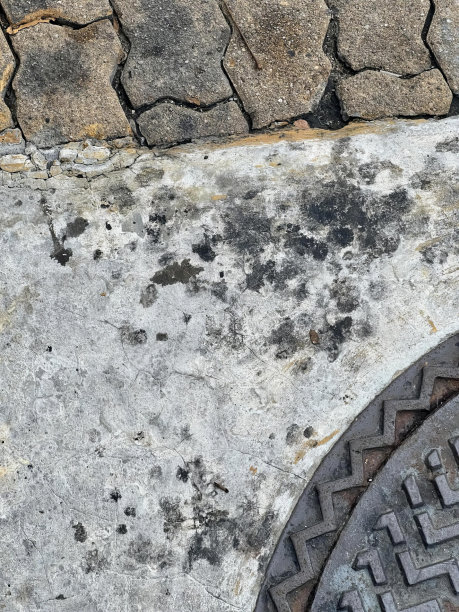 一张带有排水管和人行道的人孔的照片，一张人行道上带有金属盖的人孔的特写。图片下载