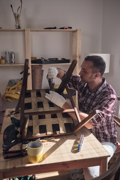 一名男子在一个小型家庭作坊里修理和修复家具。图片下载