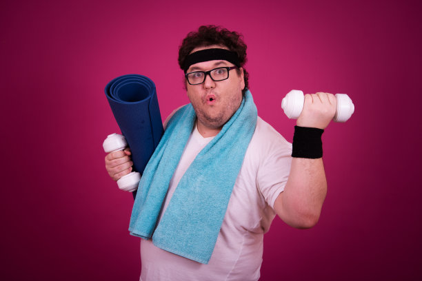 滑稽的胖子正在健身，并且贪婪地吃了一个汉堡包。复古的风格。图片下载