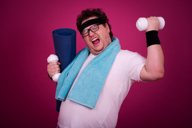 滑稽的胖子正在健身，并且贪婪地吃了一个汉堡包。复古的风格。图片下载