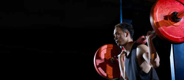 英俊肌肉的亚洲年轻人举重与奥林匹克杠铃强练习在现代健身房图片下载