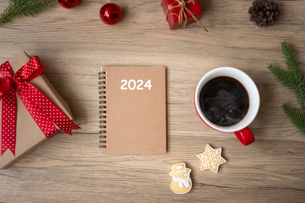 2024笔记本，黑咖啡杯，圣诞饼干和笔在木桌子上，俯视图和复制空间。圣诞节，新年快乐，目标，决心，任务清单，策略和计划概念图片下载