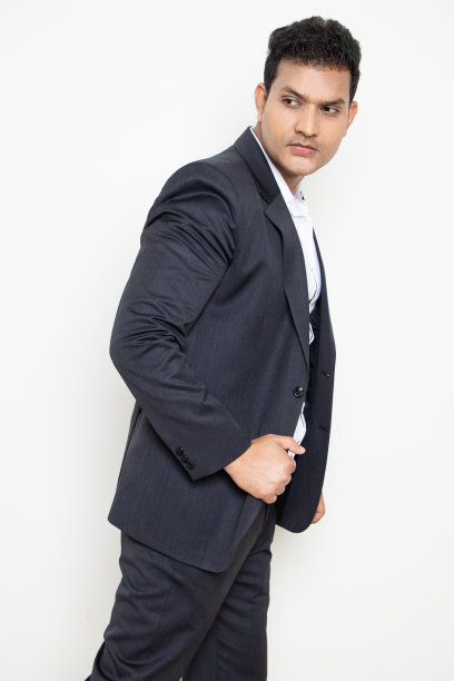 微笑英俊的年轻印度商人穿着西装，在白色背景上摆出孤立的姿势。企业的概念。图片下载