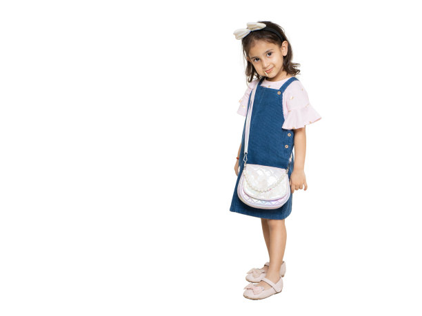 印度小女孩穿着休闲的衣服，拿着手提包，孤立地站在白色的背景上。儿童时尚肖像，复制空间。图片下载