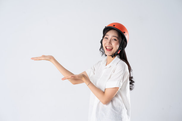 戴着白色背景的橙色头盔的女人图片下载