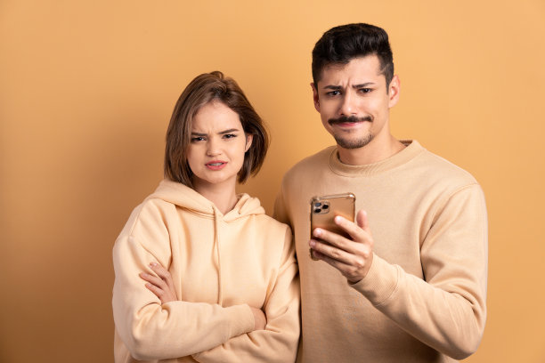 困惑的夫妇看着手机图片下载