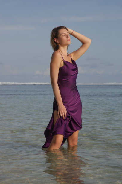 户外女模特在沙滩上的紫色缎面连衣裙，时尚优雅的夏季时尚图片下载