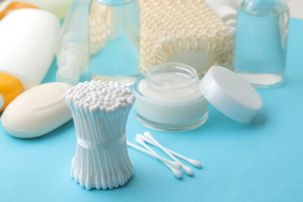 各种个人护理产品。面霜、肥皂、乳液、化妆棉和蓝色手机上的小纸条。水疗中心。图片下载