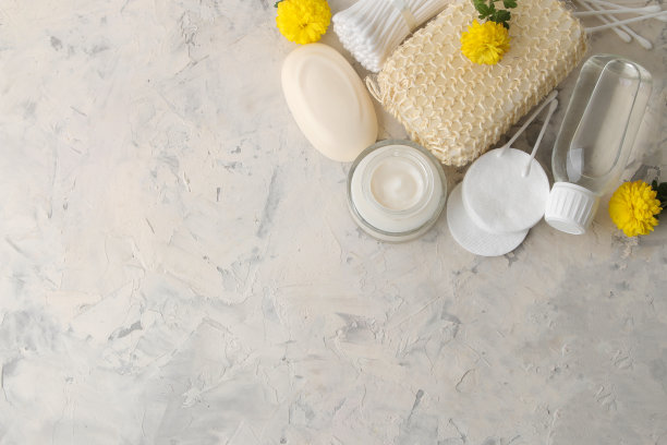 各种个人护理产品。面霜、肥皂、棉垫、毛巾、棍子和白色背景上的黄花。水疗中心图片下载