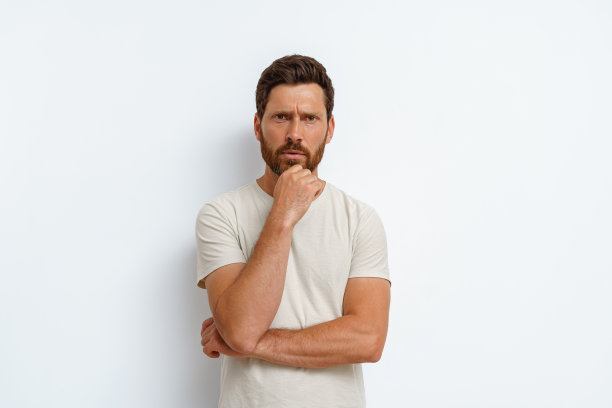 英俊的男人把手放在下巴上，若有所思地看着白色背景的相机图片下载