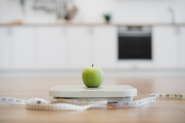 上面有苹果的天平和厨房里的卷尺图片下载