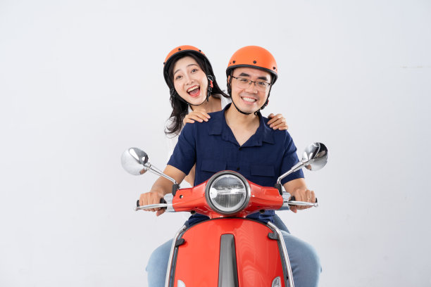 一对夫妇戴着头盔骑着摩托车图片下载