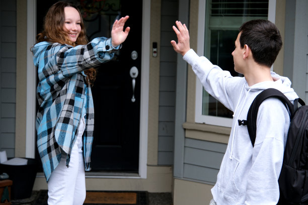 男孩带女孩回家青少年是背着公文包的朋友高中愉快的关系初恋的交流渴望在一起离别的微笑明天见你上学的时候青春期图片下载