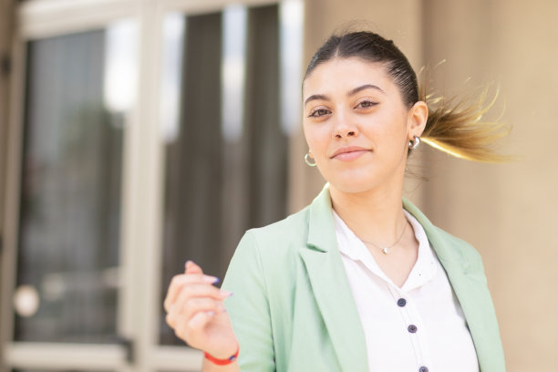 年轻女子对着镜头微笑，穿着柔和的衣服。图片下载