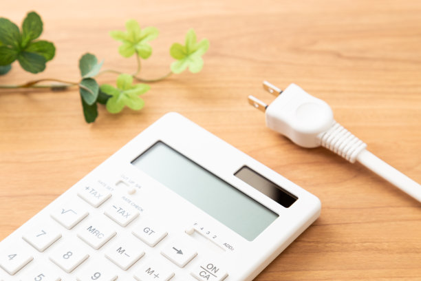 计算器和电源插头在桌子上。图片下载