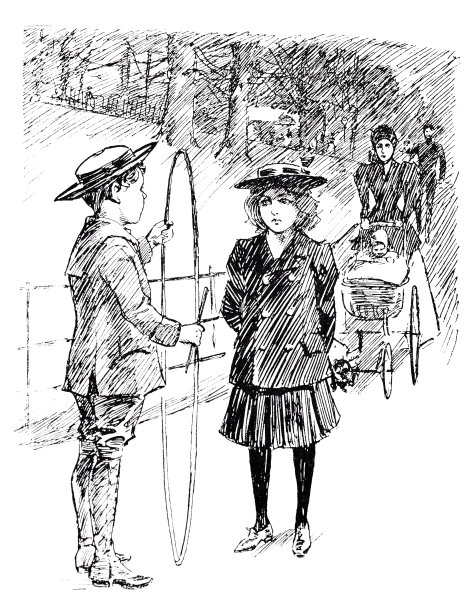 一个男孩向一个女孩展示他的大体操戒指，两人都站在街上图片下载