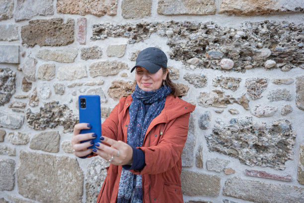 女游客在老石墙前自拍图片下载