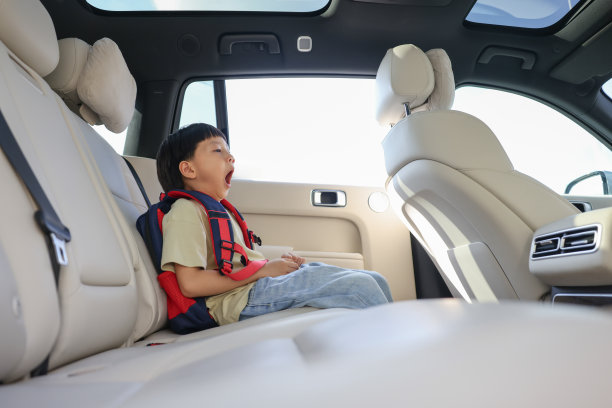 困倦的小男孩正在等他的父母开车送他去学校图片下载